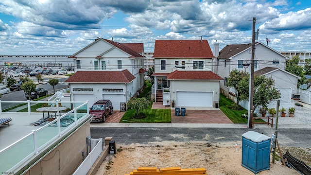 view of front of home with a garage, fence, and a residential view