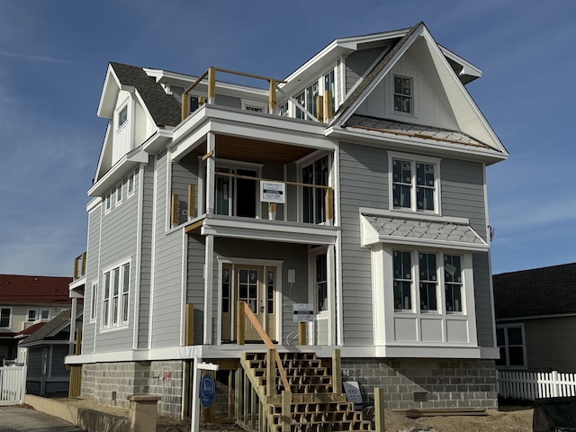 view of front of house with a shingled roof, a standing seam roof, and metal roof