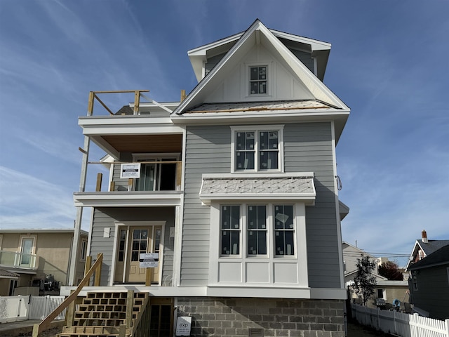 view of front of home with stairway, metal roof, a standing seam roof, fence, and board and batten siding