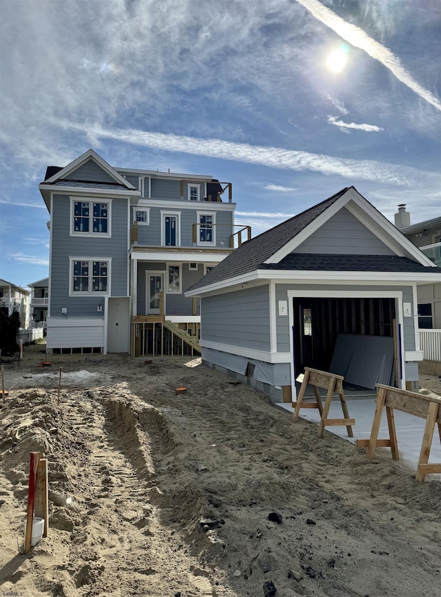 exterior space featuring a garage and roof with shingles