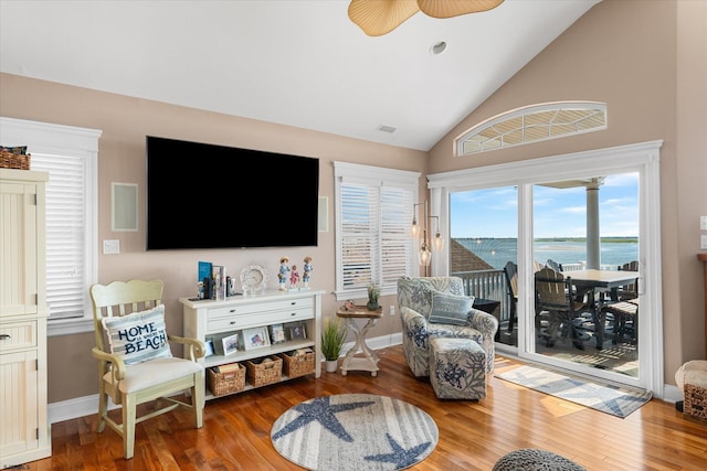 living room with lofted ceiling, baseboards, and wood finished floors