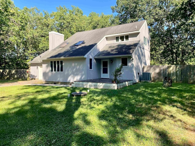 view of front of home with a front lawn and central AC