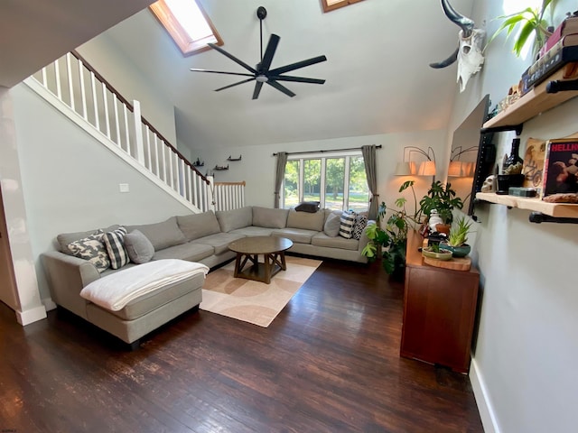 living room with hardwood / wood-style floors, high vaulted ceiling, a skylight, and ceiling fan