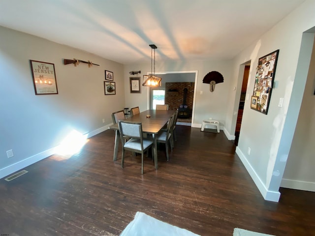 dining room featuring dark hardwood / wood-style floors and a wood stove