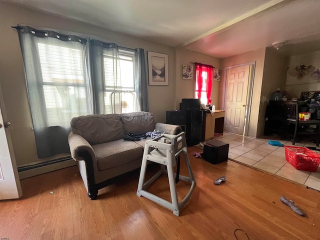 living room with a baseboard heating unit and wood-type flooring