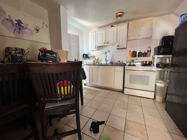 kitchen featuring decorative backsplash, white cabinetry, white stove, and light tile patterned floors