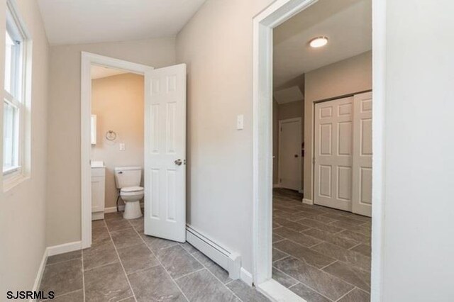 bathroom featuring a baseboard heating unit, toilet, tile patterned floors, and vanity