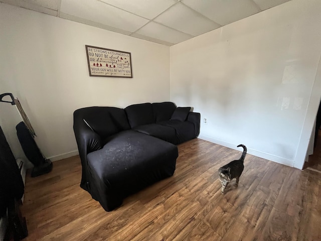 living room with hardwood / wood-style floors and a drop ceiling