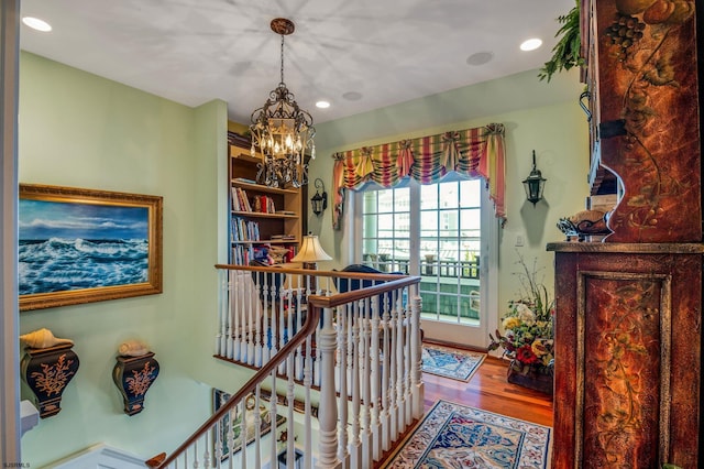 hallway with light hardwood / wood-style flooring and a chandelier