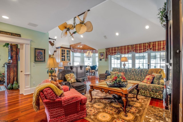 living room with lofted ceiling, hardwood / wood-style floors, and a chandelier