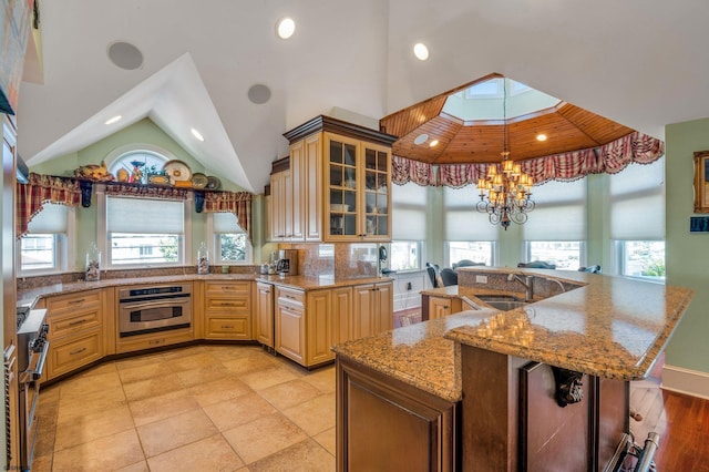 kitchen with oven, a healthy amount of sunlight, and light tile patterned floors