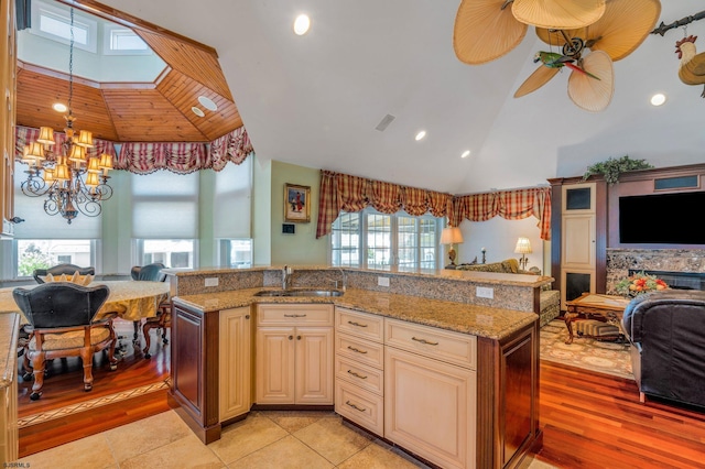 kitchen featuring a kitchen island with sink, light stone counters, sink, and light tile patterned flooring