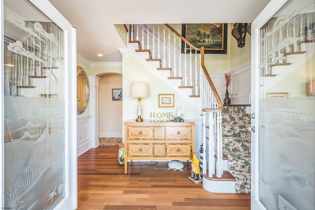 stairs featuring ornamental molding and hardwood / wood-style floors