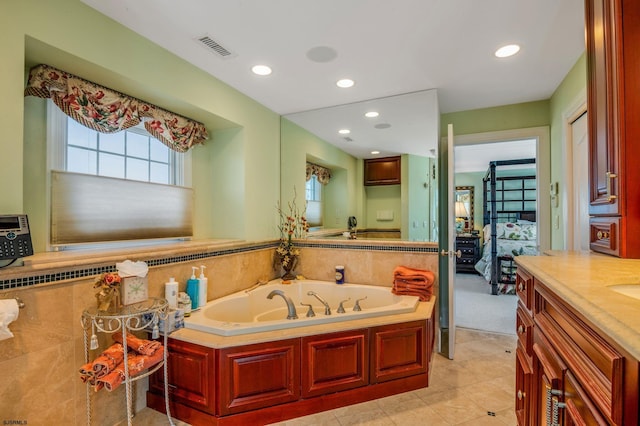 bathroom featuring tile patterned flooring, a tub to relax in, and vanity