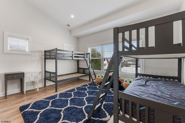 bedroom featuring high vaulted ceiling and light hardwood / wood-style floors