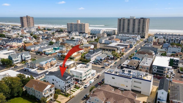 drone / aerial view featuring a beach view and a water view