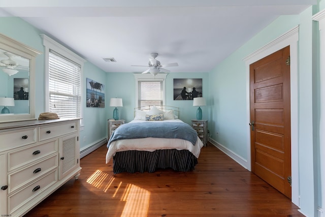 bedroom with baseboards, visible vents, a ceiling fan, dark wood-type flooring, and baseboard heating