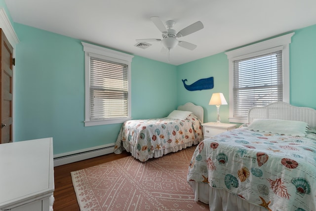 bedroom featuring multiple windows, visible vents, baseboard heating, and wood finished floors