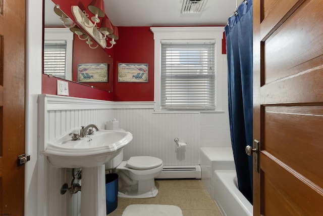 full bath with a wainscoted wall, visible vents, toilet, baseboard heating, and shower / bath combo