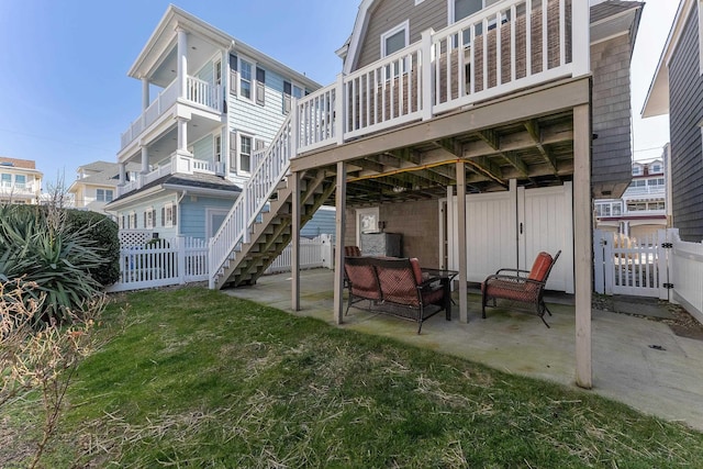 back of house with stairs, a lawn, a patio area, and fence