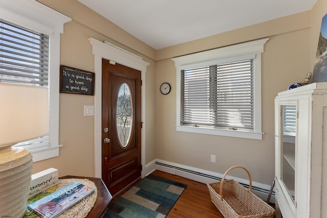 entryway featuring baseboards, a baseboard heating unit, and wood finished floors