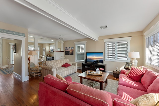 living area with a baseboard heating unit, visible vents, baseboards, beam ceiling, and wood-type flooring