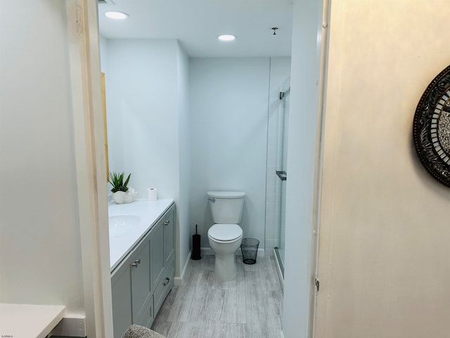 bathroom with a shower with door, vanity, toilet, and wood-type flooring