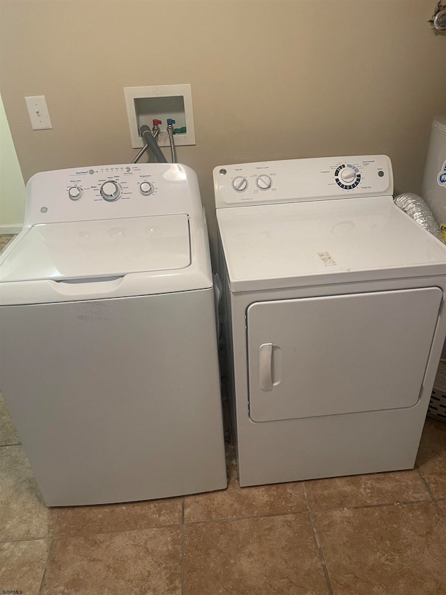 clothes washing area featuring separate washer and dryer and tile patterned flooring