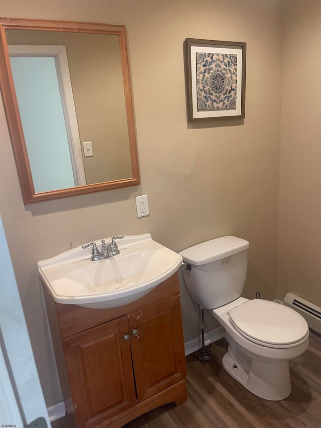 bathroom featuring a baseboard heating unit, vanity, toilet, and hardwood / wood-style floors