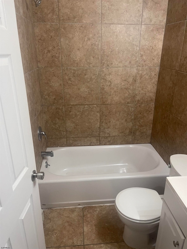 full bathroom featuring tile patterned flooring, toilet, tiled shower / bath combo, and vanity