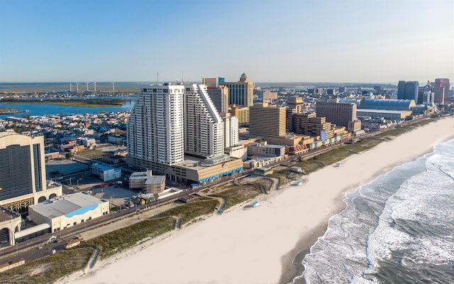 drone / aerial view with a water view and a beach view