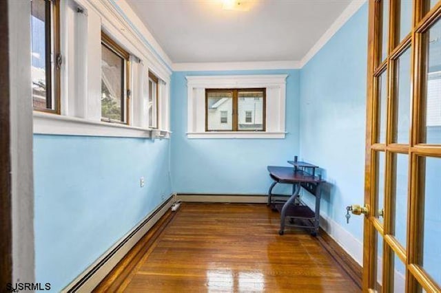 unfurnished room featuring a baseboard radiator, dark hardwood / wood-style floors, and crown molding