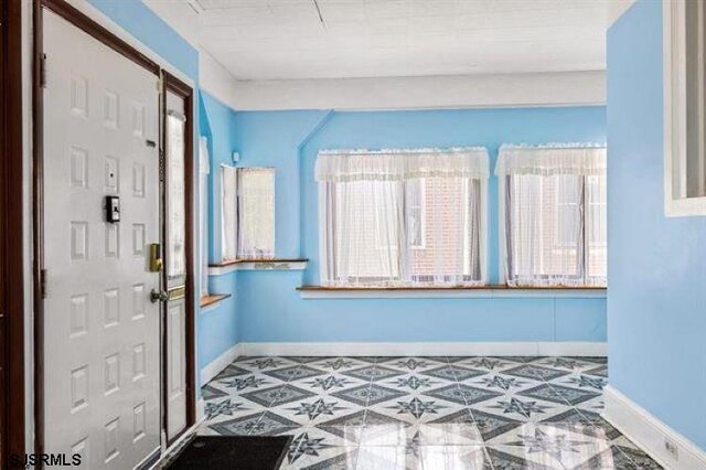 unfurnished living room with beamed ceiling, dark hardwood / wood-style flooring, ornamental molding, a baseboard heating unit, and ceiling fan