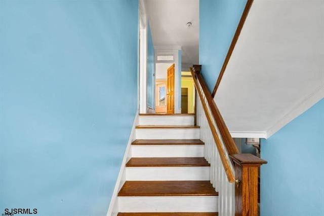 stairway featuring crown molding