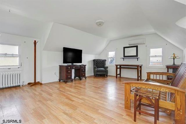 sitting room with a healthy amount of sunlight, radiator heating unit, and light hardwood / wood-style flooring