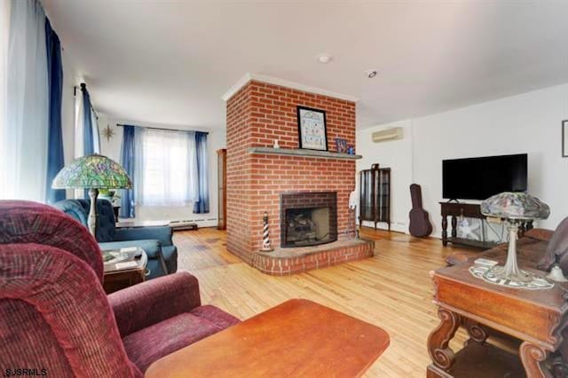 living area with an AC wall unit, a brick fireplace, wood finished floors, and baseboard heating