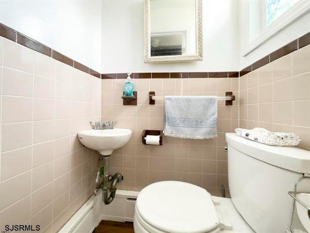 bathroom with tile walls and toilet