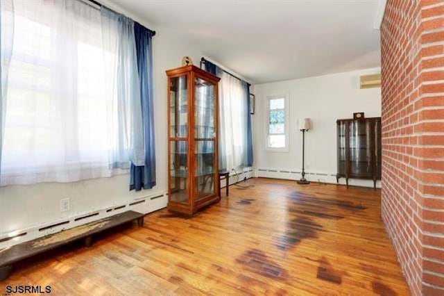 empty room featuring a baseboard heating unit and wood finished floors