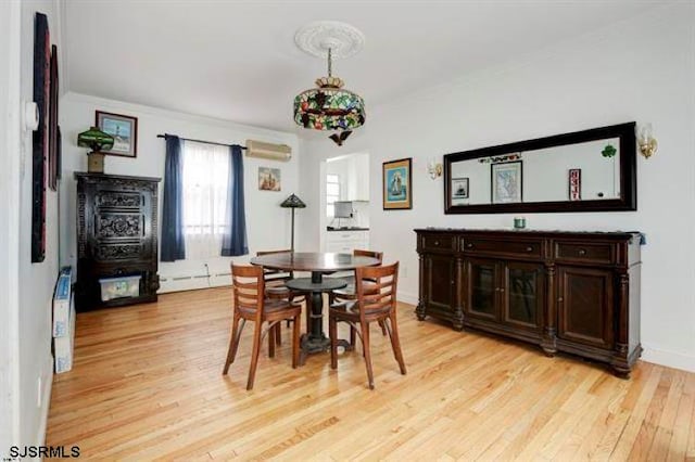 dining room featuring light wood-type flooring, a wall unit AC, and baseboard heating