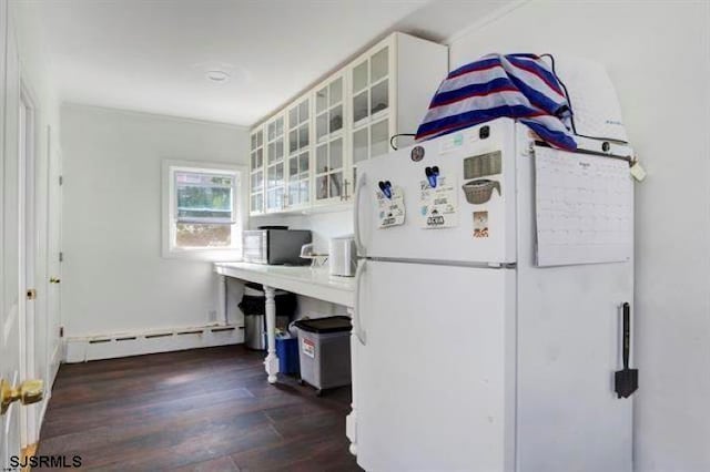 interior space with white refrigerator, baseboard heating, white cabinetry, dark hardwood / wood-style floors, and ornamental molding