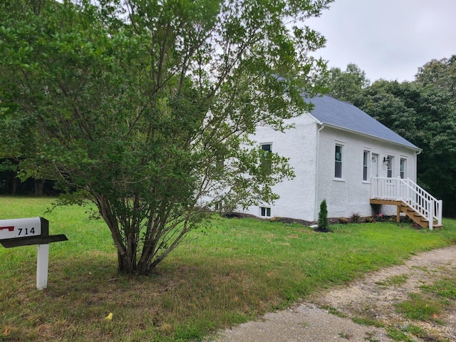 view of side of home with a yard