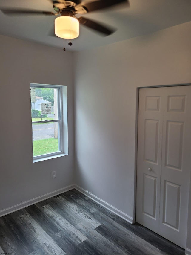 spare room with dark wood-type flooring and ceiling fan