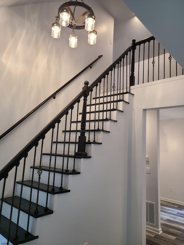 stairs featuring a notable chandelier and hardwood / wood-style flooring