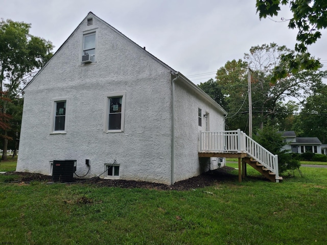 view of home's exterior with central AC unit, a lawn, a wooden deck, and cooling unit