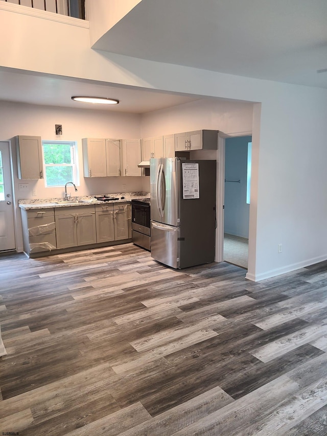 kitchen featuring sink, gray cabinets, stainless steel fridge, range with electric stovetop, and dark wood-type flooring