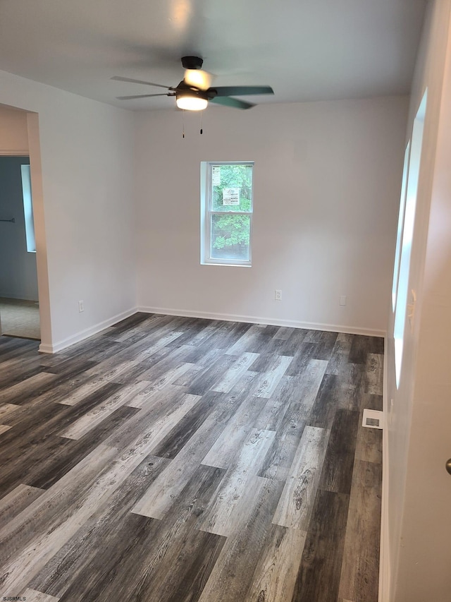 spare room with dark wood-type flooring and ceiling fan