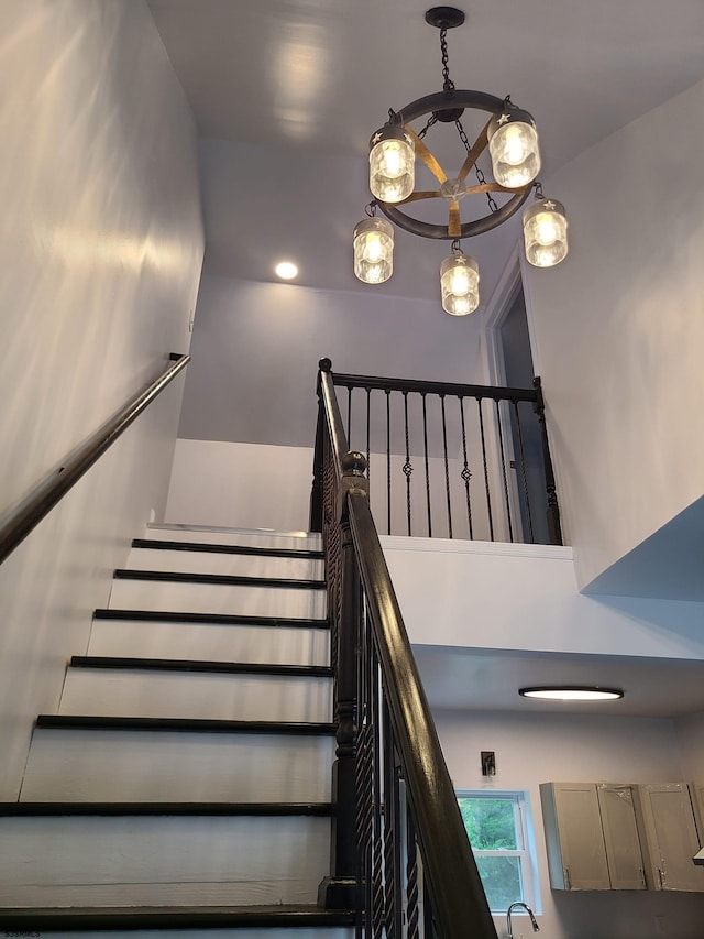 stairs with a chandelier and a high ceiling