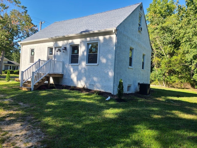 view of front of property with central AC unit and a front lawn