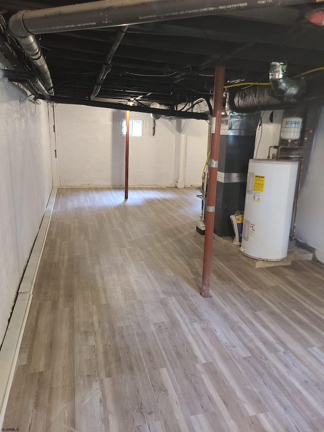 basement with wood-type flooring, water heater, and heating unit