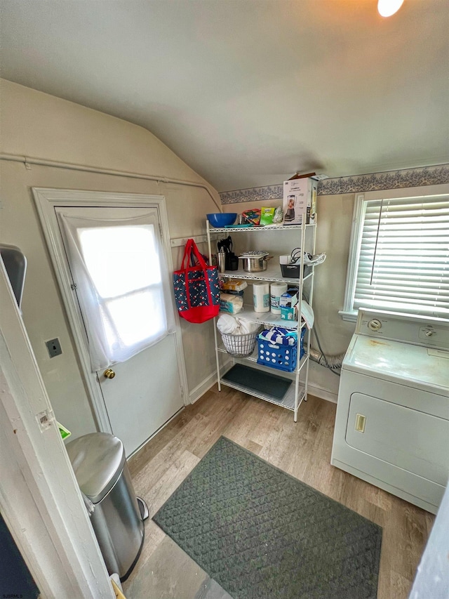 interior space with lofted ceiling, washer / dryer, and wood-type flooring